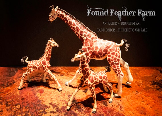 A Resin and Hard Rubber Toy Figurine of a Giraffe Mother and Her Twin Babies