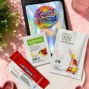 May include: A collection of Herbalife nutrition products including a black pouch labeled Krunch Busy Mom Energy Kit, a Herbal Tea Concentrate packet, a Herbalife Skin Collagen Beauty Booster packet, and a red Liftoff drink mix packet.