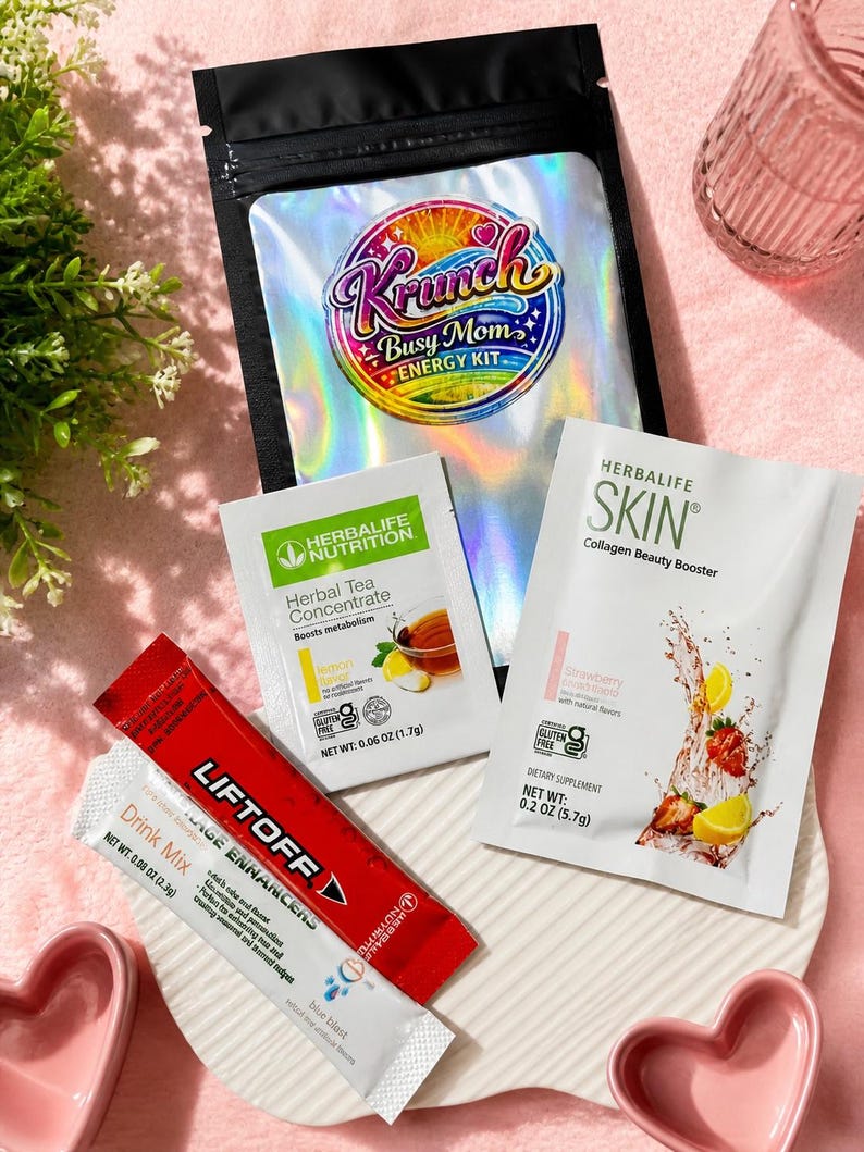 May include: A collection of Herbalife nutrition products including a black pouch labeled Krunch Busy Mom Energy Kit, a Herbal Tea Concentrate packet, a Herbalife Skin Collagen Beauty Booster packet, and a red Liftoff drink mix packet.