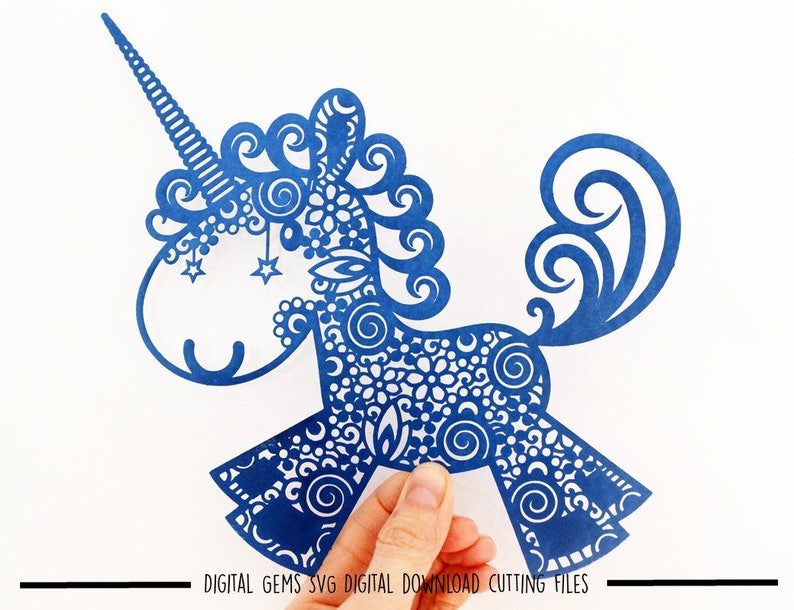 K&ouml;nnte beinhalten: Blauer, filigraner Papierschnitt einer Einhorn mit einem Horn und einem lockigen Schwanz. Das Einhorn ist mit Spiralen und Sternen verziert.