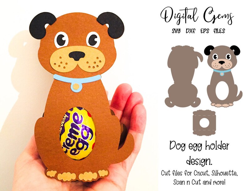 May include: A brown dog-shaped egg holder with black ears, a blue collar, and a Creme Egg inside. The design is made of paper and is held in a hand. Text on the right says "Dog egg holder design."
