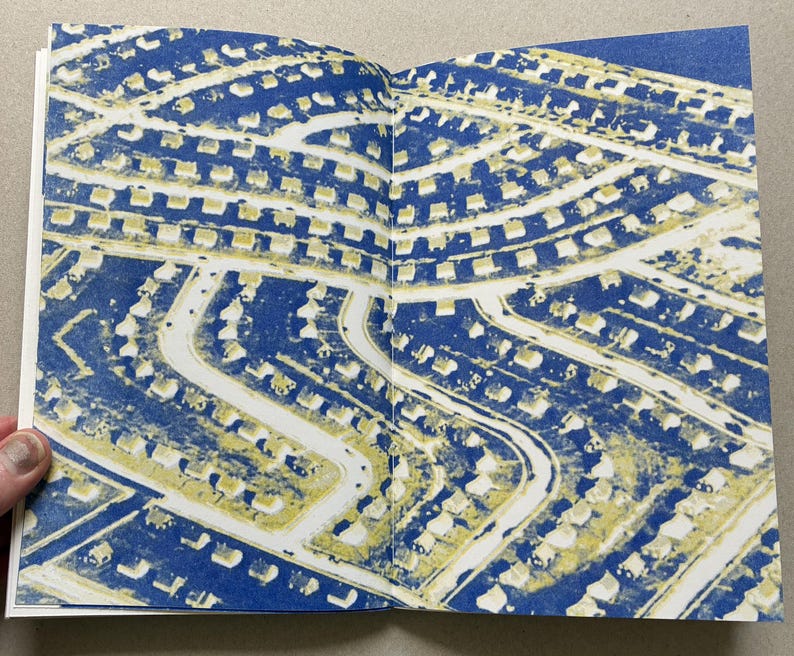 K&ouml;nnte beinhalten: Doppelseite aus einem Buch mit einer Luftaufnahme eines Wohngebiets. Der Druck verwendet ein blaues und gelbes Farbschema. Die H&auml;user sind gelb, die Stra&szlig;en wei&szlig; und der Hintergrund blau.