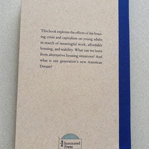 K&ouml;nnte beinhalten: Buchcover mit Text, der die Auswirkungen der Wohnungskrise und des Kapitalismus auf junge Erwachsene untersucht. Der Einband ist beige mit blauem R&uuml;cken und dem Text "Illuminated Press".