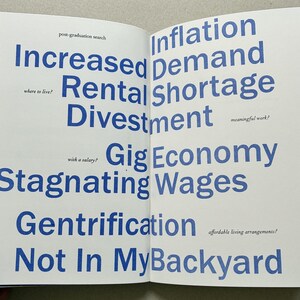 K&ouml;nnte beinhalten: Offene Buchseiten mit blauem Text auf wei&szlig;em Hintergrund. Der Text enth&auml;lt S&auml;tze wie "Erh&ouml;hter Mietpreis", "Inflationsnachfrage" und "Nicht in meinem Hinterhof". Die W&ouml;rter sind in einer fetten, serifenlosen Schrift.