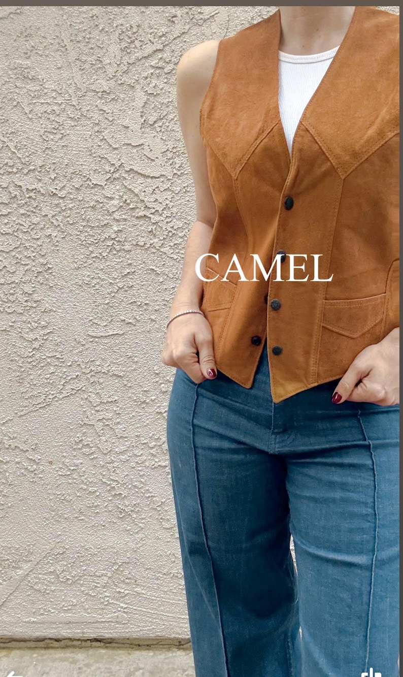 Puede incluir: Chaleco de ante color camel con dise&ntilde;o de cuello en V y botones negros. El chaleco tiene dos bolsillos delanteros y se lleva sobre una camiseta blanca. La palabra "CAMEL" est&aacute; impresa en el chaleco. El modelo lleva vaqueros azules.