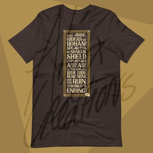 May include: A dark brown t-shirt featuring a rectangular design with gold lettering. The text reads "ARISE. RIDERS OF ROHAN! SPEAR SHALL BE SHAKEN. SHIELD BE SPLINTERED A DAY. RIDE RIDE NOW. RIDE FOR RUIN AND THE WORLD'S ENDING!"