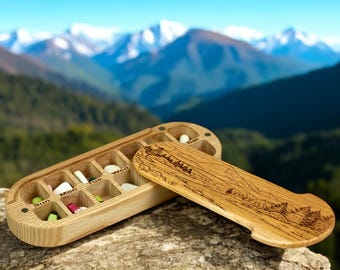 Pastillero de madera para 7 días con paisaje de montaña grabado en la tapa "N22"