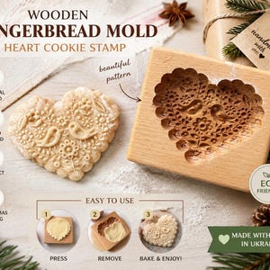 May include: A rectangular wooden gingerbread mold featuring a heart-shaped cavity with an intricate carved design of two birds and floral patterns, accompanied by a matching heart-shaped cookie and instructional text for baking.