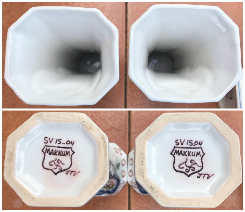 Puede incluir: Dos jarrones de cer&aacute;mica blanca con un patr&oacute;n floral azul y blanco. La parte inferior de cada jarr&oacute;n tiene un sello marr&oacute;n que dice "SV 15-04 MAKKUM" con un dise&ntilde;o estilizado y las letras "JTV".