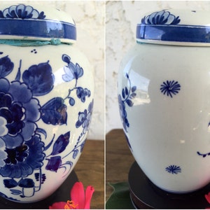 May include: A white and blue ceramic jar with a lid. The jar is decorated with blue floral patterns and a blue band around the lid. The jar is approximately 8 inches tall.