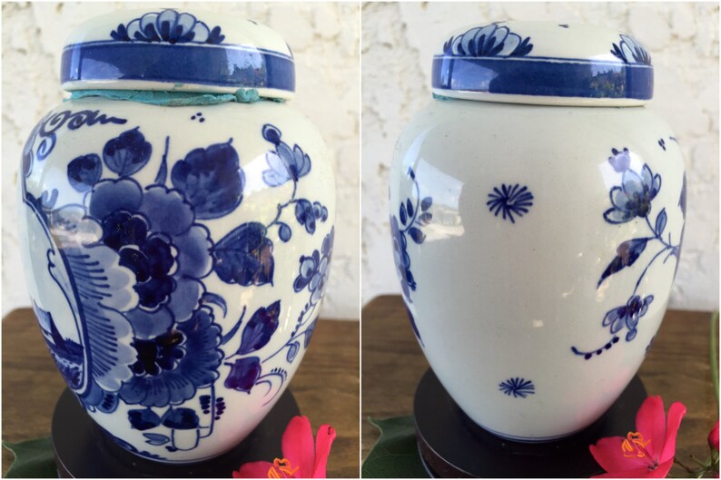 May include: A white and blue ceramic jar with a lid. The jar is decorated with blue floral patterns and a blue band around the lid. The jar is approximately 8 inches tall.
