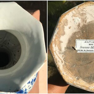 May include: An antique, octagonal porcelain vase with a white and blue floral pattern. The interior is white, and the base features a label with text. This vintage vase is a testament to craftsmanship and historical design.