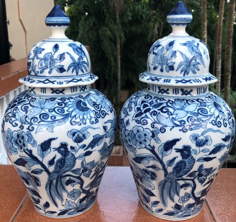 Puede incluir: Dos jarrones de jengibre de porcelana azul y blanca con intrincados dise&ntilde;os florales y de p&aacute;jaros. Los jarrones tienen una tapa con una banda decorativa alrededor de la parte superior.