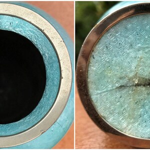 Pu&ograve; includere: Un vaso in ceramica blu turchese con un bordo argentato. Il vaso ha una crepa sul fondo e un bordo argentato intorno alla parte superiore.