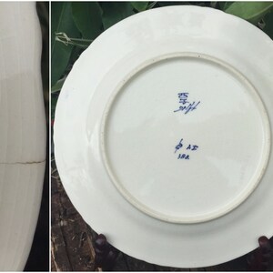 May include: A white ceramic plate with blue markings on the bottom. The markings include the number "25" and the letters "A.Z. 388".
