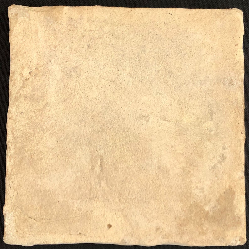 May include: A square, off-white ceramic tile with a textured surface. The tile has a slightly irregular edge and a matte finish. The colour is a warm, neutral tone, suitable for various design applications.