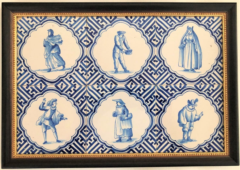 Puede incluir: Obra de arte enmarcada con seis azulejos de cer&aacute;mica azules y blancos, cada uno representando una figura con vestimenta hist&oacute;rica. Los azulejos est&aacute;n colocados sobre un fondo estampado y enmarcados en negro con un borde interior dorado. Una pieza decorativa.