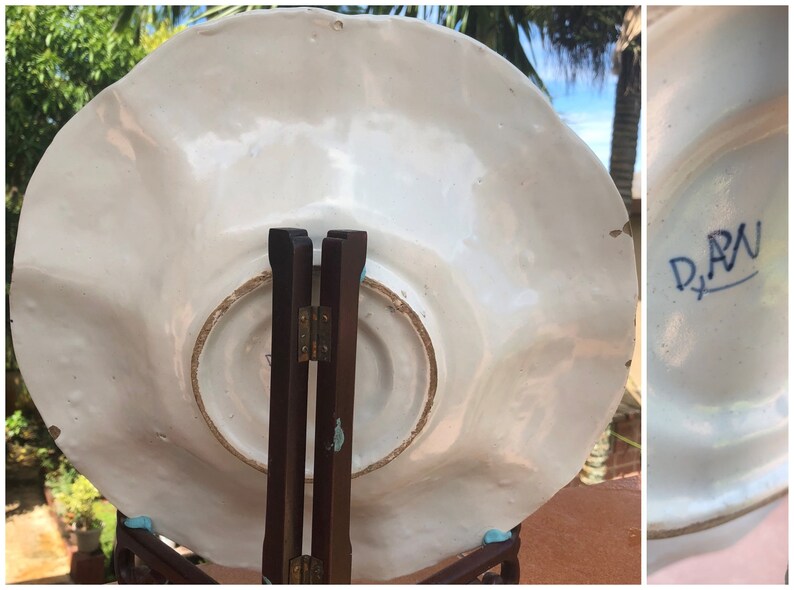 K&ouml;nnte beinhalten: Wei&szlig;e Keramikplatte mit gewelltem Rand und einem blauen und wei&szlig;en Blumenmuster. Die R&uuml;ckseite der Platte tr&auml;gt eine blaue Markierung mit der Aufschrift "D.A.N."