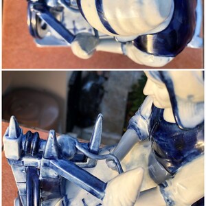 K&ouml;nnte beinhalten: Eine blau-wei&szlig;e Porzellanfigur, die eine Person an einem Spinnrad zeigt. Die Figur hat ein traditionelles Design mit komplizierten Details. Die Farbpalette ist haupts&auml;chlich blau und wei&szlig;, mit klar definierten Details.