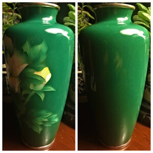 Puede incluir: Un jarr&oacute;n verde de cloisonn&eacute; con un dise&ntilde;o floral. El jarr&oacute;n tiene una flor blanca y amarilla con hojas verdes.