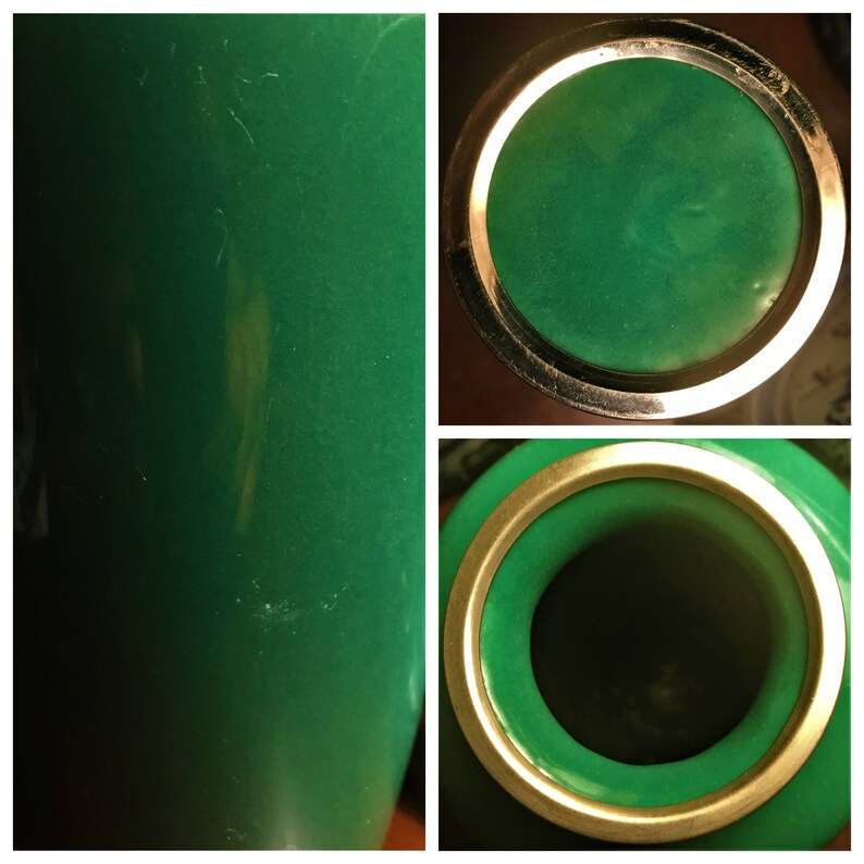 Puede incluir: Un jarr&oacute;n de cer&aacute;mica verde con un borde dorado. El jarr&oacute;n tiene un acabado liso y brillante y una forma redonda. El jarr&oacute;n est&aacute; vac&iacute;o.