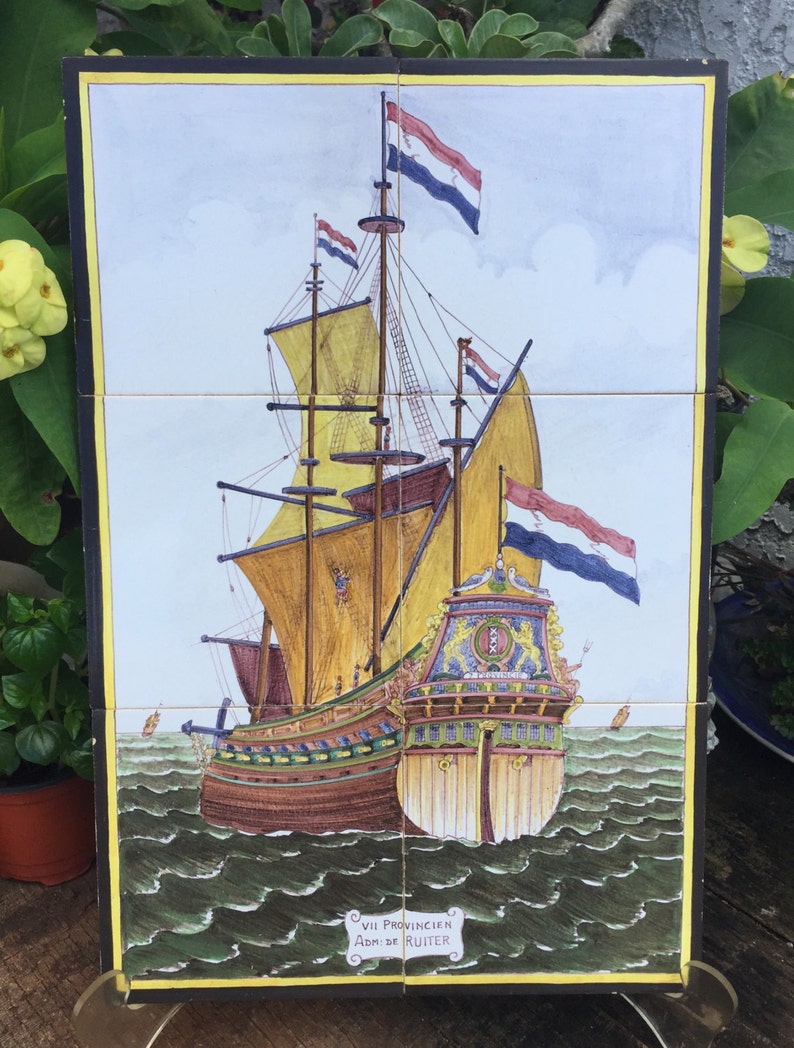 Puede incluir: Un azulejo vintage que representa un barco holand&eacute;s con una vela amarilla y varias banderas. El barco navega en un mar verde con olas. El azulejo tiene un borde amarillo y el texto "VII Provincien Adm. de Ruiter" en un &oacute;valo negro.