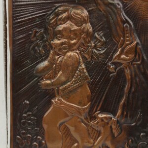 May include: A copper wall plaque with a raised relief design of a young girl with pigtails standing next to a tree. The girl is wearing a dress and holding a bird in her hand.
