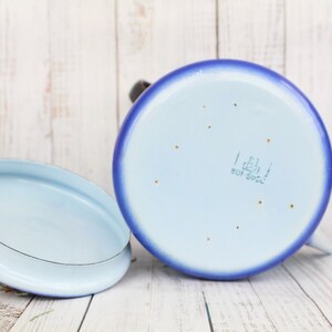 Op de afbeelding: Een blauwe en lichtblauwe emaille theepot met een deksel. De bodem van de theepot heeft een gouden stempel met de tekst "1.6l 901 5902".
