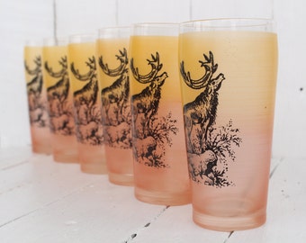 May include: Set of six frosted glass tumblers with a gradient from yellow to pink. Each glass features a black and white illustration of a deer in a forest setting.