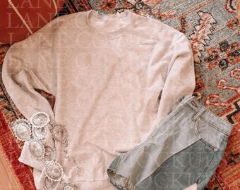 May include: A light grey sweatshirt with long sleeves and a crew neck, laid out on a patterned rug with a pair of denim shorts and a silver chain belt.