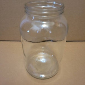 May include: A clear glass jar with a wide mouth and a rounded bottom.
