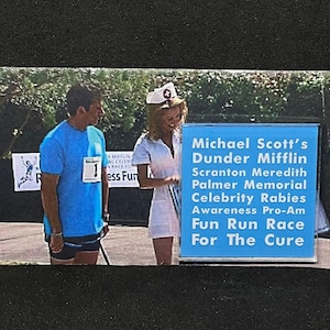 May include: A photo of Michael Scott and a woman dressed as a nurse, participating in a "Michael Scott's Dunder Mifflin Scranton Meredith Palmer Memorial Celebrity Rabies Awareness Pro-Am Fun Run Race For The Cure".
