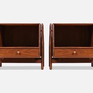 May include: Two matching wooden nightstands with a warm brown finish. Each nightstand has an open top shelf, a single drawer with a gold-colored knob, and a simple, modern design. The nightstands are approximately 24 inches wide.