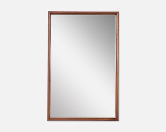 May include: A rectangular mirror with a brown wooden frame.