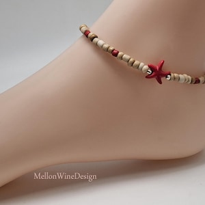 May include: Ankle bracelet featuring wooden beads in natural and red tones, accented by a vibrant red starfish charm. The bracelet is strung on a delicate cord, creating a beachy, bohemian aesthetic. A stylish accessory for adding a touch of coastal charm.