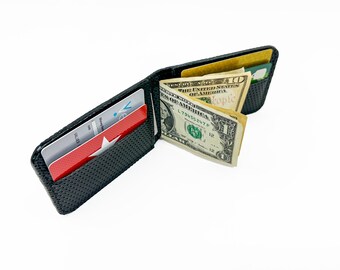 May include: A black leather wallet with a textured surface, open to reveal two credit cards and a stack of US dollar bills. The bills include a $1 bill and a $10 bill.