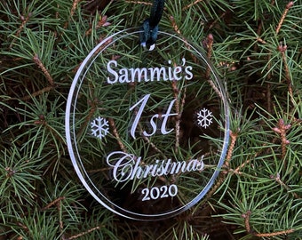 Könnte beinhalten: Klare gläserne Weihnachtskugel mit dem Text "Sammie's 1st Christmas 2020" und Schneeflocken auf einem grünen Weihnachtsbaum.