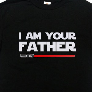 May include: Black t-shirt with the text "I AM YOUR FATHER" in white letters and a red lightsaber graphic.