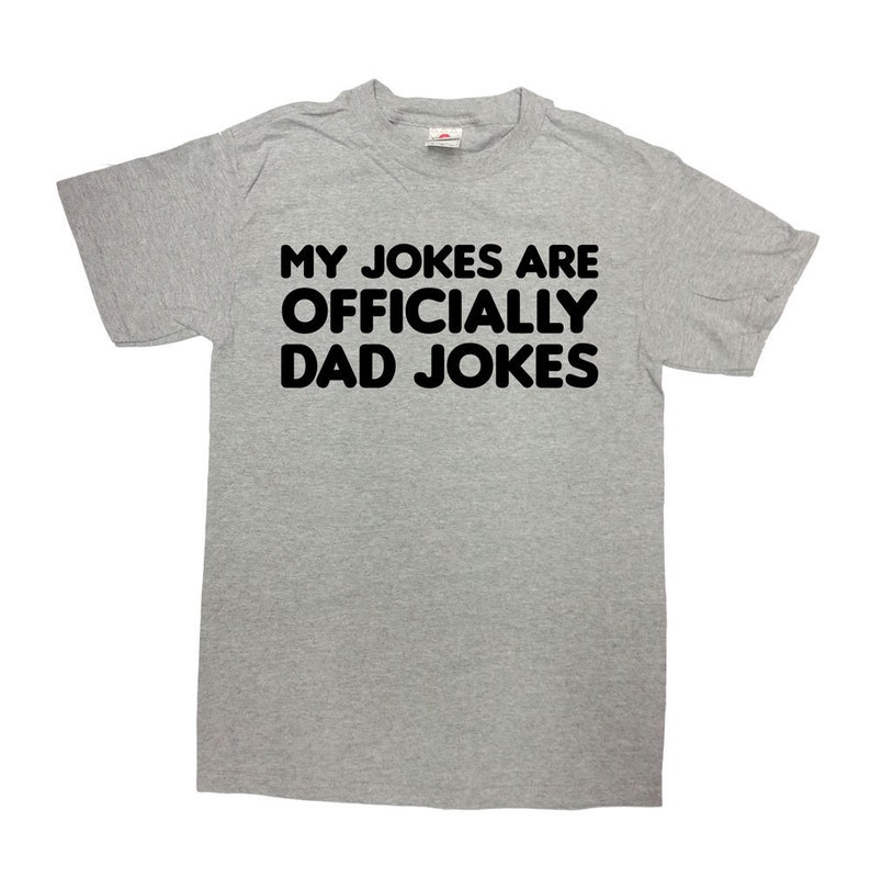 May include: A gray t-shirt with black text that reads "My jokes are officially dad jokes."