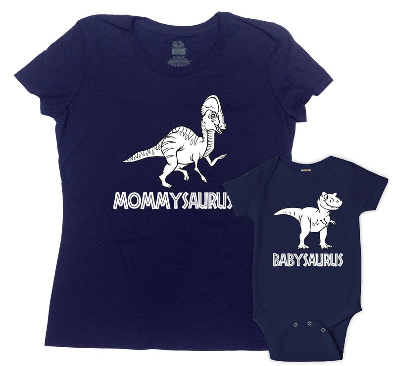 Puede incluir: Una camiseta azul marino con un dinosaurio blanco y el texto "Mommyaurus" y un body de beb&eacute; azul marino con un dinosaurio blanco y el texto "Babysaurus".