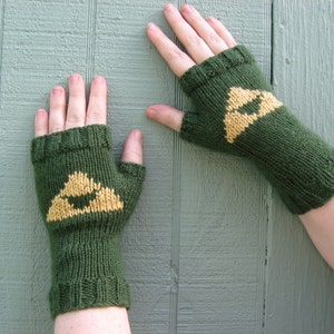 Puede incluir: Un par de guantes sin dedos verdes con un diseño de triángulo amarillo. Los guantes están tejidos y tienen una muñequera.
