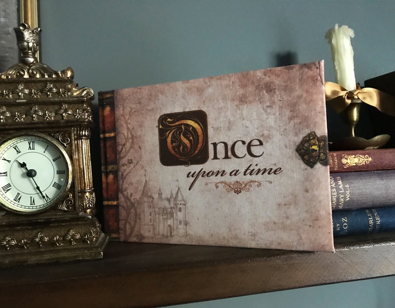 May include: A brown book with the title "Once upon a time" in gold lettering. The book is decorated with a gold key and a castle illustration.