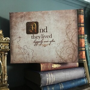 May include: A vintage-style book cover with a brown background and a decorative vine design. The cover features the text "And they lived happily ever after" in a stylized font. The book is sitting on a stack of other books.