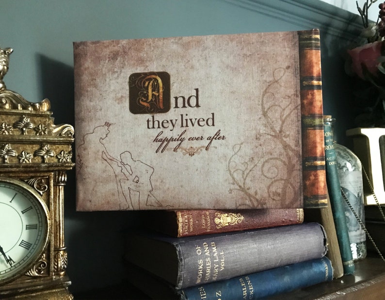 May include: A vintage-style book cover with a brown background and a decorative vine design. The cover features the text "And they lived happily ever after" in a stylized font. The book is sitting on a stack of other books.