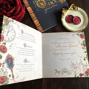 May include: Open invitation card with a fairytale theme. The card features a clock, roses, and a mirror with a rose. The text reads "Be our Guest" and "happily ever after". Includes a small plate with two red wax seals.