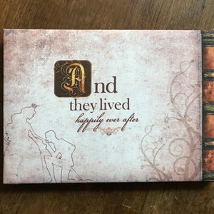 May include: A vintage-style book cover with a decorative floral design and the text "And they lived happily ever after".