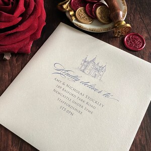 May include: An ivory envelope with a castle illustration and the words "Kindly deliver to" in elegant script. A wooden handled wax stamp and gold and red wax seals are on a decorative dish. A red rose is in the corner.