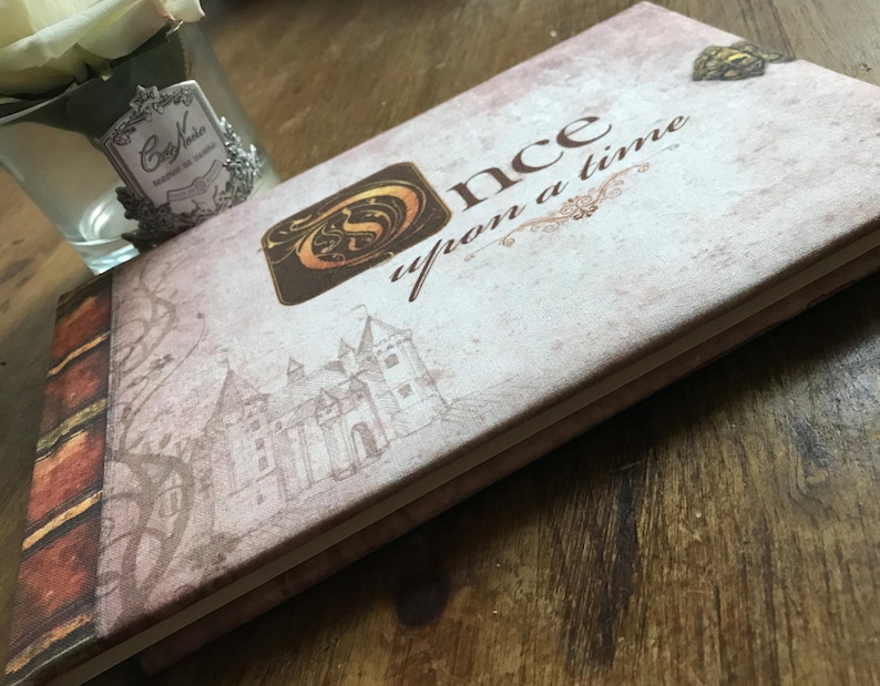 May include: A vintage-style journal with a brown and white cover. The cover features a castle illustration and the text "Once upon a time".