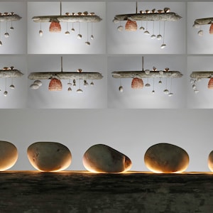 May include: Five smooth, round, light brown stones are arranged in a row on a weathered, light brown wooden surface. The stones are illuminated from below, casting a warm glow.