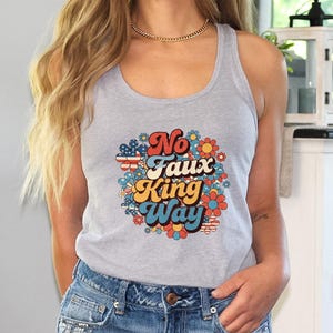 May include: A gray tank top with the text "No Faux King Way" in a retro font, surrounded by a floral design with red, white, blue, orange, and yellow flowers. The tank top is paired with blue denim shorts.